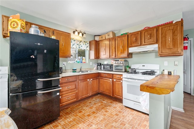 26166 Alpine Ln, Twin Peaks, CA 92391 - kitchen featuring black appliances, under cabinet range hood, a sink, light countertops, and brown cabinetry