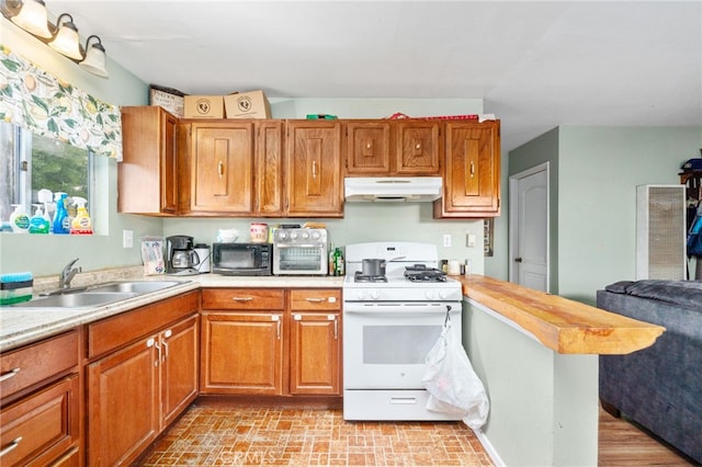 26166 Alpine Ln, Twin Peaks, CA 92391 - kitchen with gas range gas stove, under cabinet range hood, a sink, light countertops, and black microwave