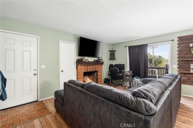 26166 Alpine Ln, Twin Peaks, CA 92391 - living room with a brick fireplace, light wood-type flooring, and a desk