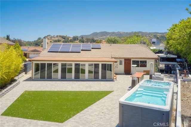 3076 Wauneta St, Newbury Park, CA 91320 - back of property with a hot tub, a mountain view, solar panels, a chimney, and a patio area