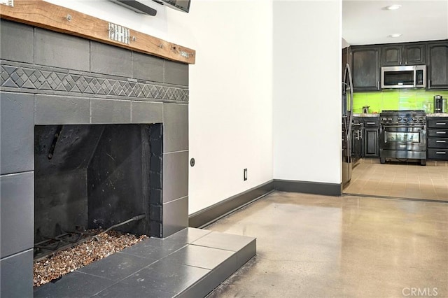 3076 Wauneta St, Newbury Park, CA 91320 - detailed view of stainless steel appliances, baseboards, finished concrete flooring, decorative backsplash, and a tiled fireplace