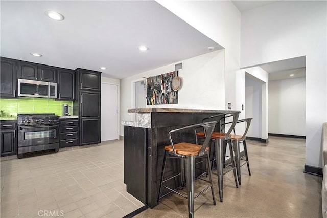 3076 Wauneta St, Newbury Park, CA 91320 - indoor dry bar with stainless steel microwave, black range with gas stovetop, backsplash, baseboards, and recessed lighting