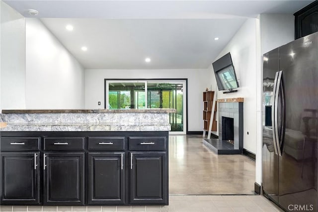 3076 Wauneta St, Newbury Park, CA 91320 - kitchen with stainless steel fridge, recessed lighting, dark cabinetry, a tiled fireplace, and baseboards