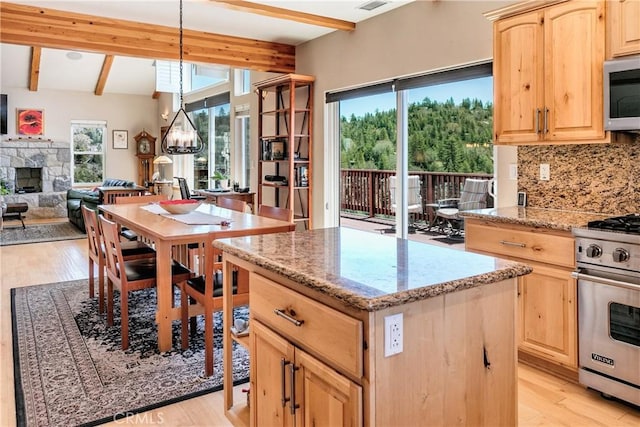26855 Inyo Ct, Lake Arrowhead, CA 92352 - kitchen with light brown cabinets, appliances with stainless steel finishes, beamed ceiling, a center island, and a fireplace
