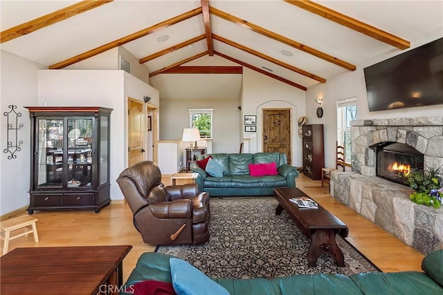 26855 Inyo Ct, Lake Arrowhead, CA 92352 - living area with wood finished floors, a stone fireplace, plenty of natural light, beam ceiling, and high vaulted ceiling