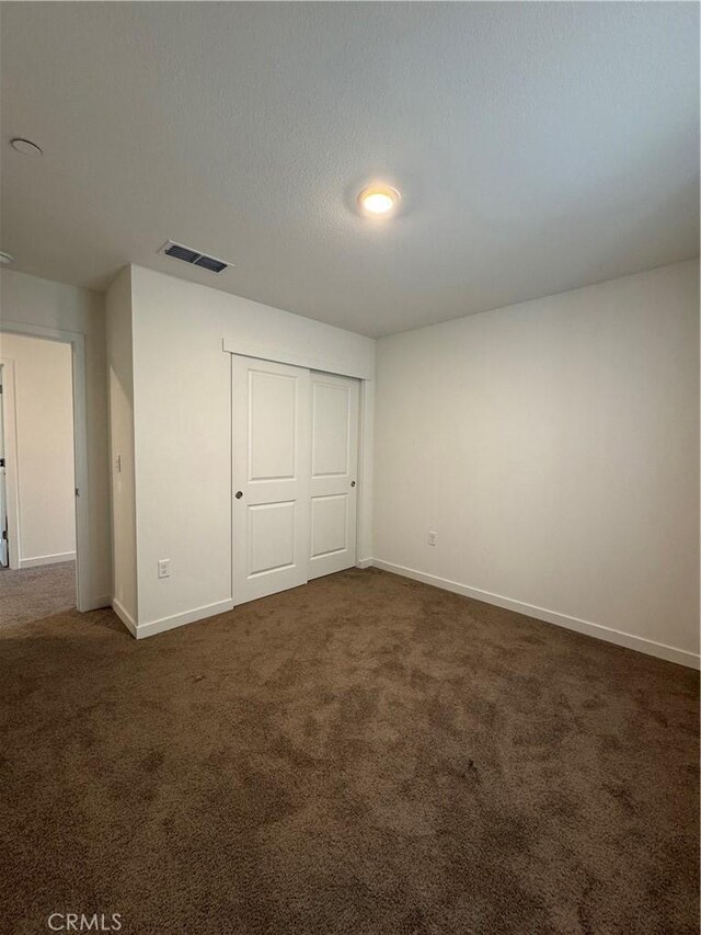 1147 Lentil Way, Chico, CA 95928 - unfurnished bedroom with dark carpet, baseboards, and a closet