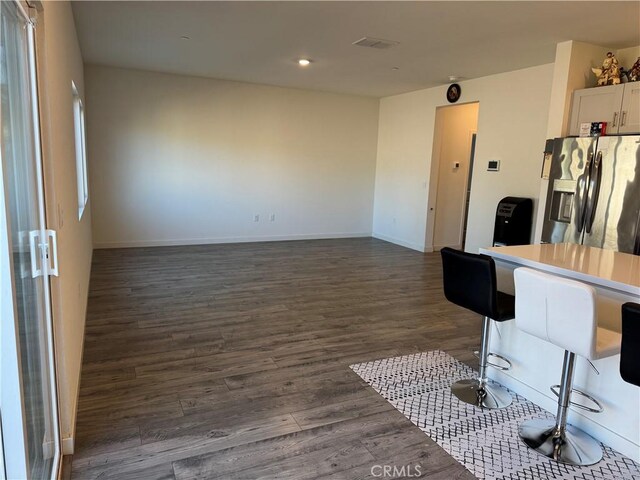 1147 Lentil Way, Chico, CA 95928 - kitchen with stainless steel fridge, dark wood finished floors, baseboards, recessed lighting, and a kitchen bar