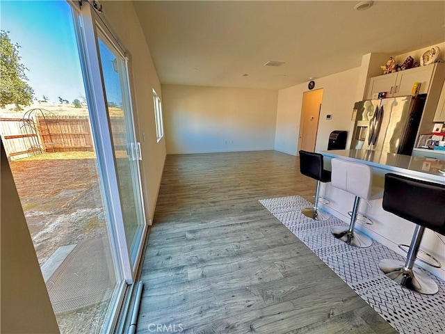 1147 Lentil Way, Chico, CA 95928 - kitchen featuring stainless steel fridge with ice dispenser, a kitchen bar, wood finished floors, white cabinetry, and open floor plan