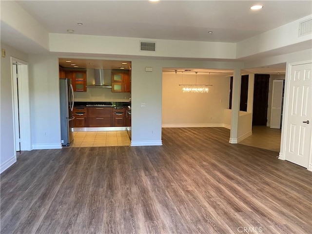 107 N Swall Dr Unit 304, Los Angeles, CA 90048 - kitchen with freestanding refrigerator, wall chimney range hood, open floor plan, baseboards, and wood finished floors