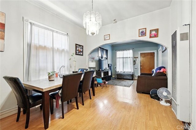 1600 E 33rd St, Los Angeles, CA 90011 - dining area with a heating unit, arched walkways, light wood-style floors, ornamental molding, and a chandelier
