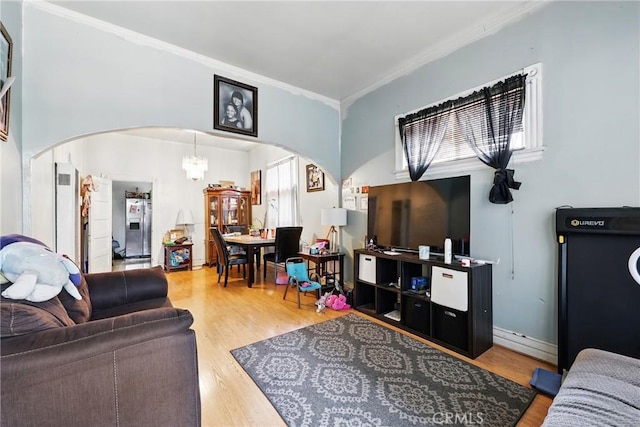 1600 E 33rd St, Los Angeles, CA 90011 - living room featuring arched walkways, wood finished floors, crown molding, and a chandelier
