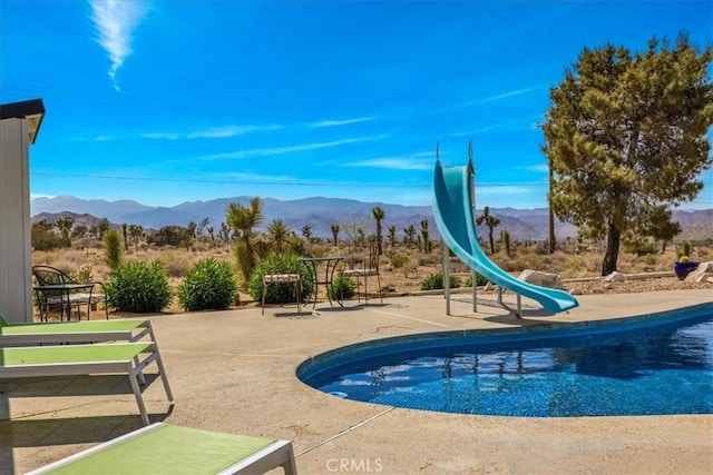 9124 Joshua Ln, Yucca Valley, CA 92284 - swimming pool with a water slide, a mountain view, and a patio