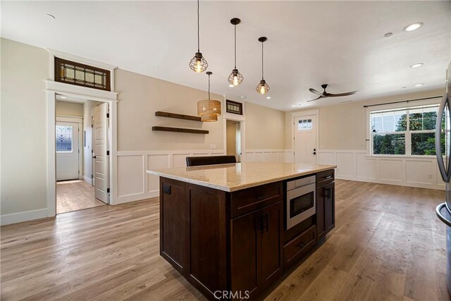 13654 Andover Dr, Magalia, CA 95954 - kitchen featuring stainless steel microwave, ceiling fan, a decorative wall, dark brown cabinets, and light wood-type flooring