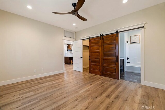 13654 Andover Dr, Magalia, CA 95954 - unfurnished bedroom featuring a barn door, light wood-style floors, ensuite bath, baseboards, and recessed lighting