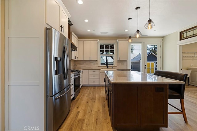 13654 Andover Dr, Magalia, CA 95954 - kitchen with stainless steel appliances, light wood-style floors, a kitchen breakfast bar, a center island, and recessed lighting