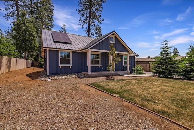 13654 Andover Dr, Magalia, CA 95954 - view of front facade with board and batten siding, roof mounted solar panels, covered porch, and metal roof