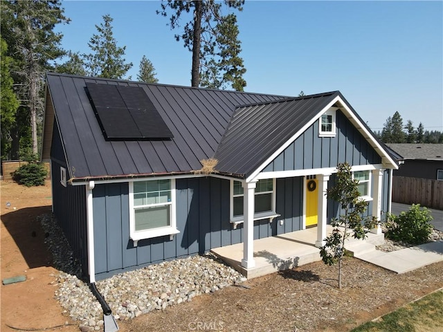 13654 Andover Dr, Magalia, CA 95954 - view of front of property featuring board and batten siding, roof mounted solar panels, and metal roof