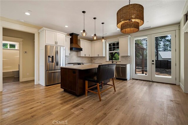 13654 Andover Dr, Magalia, CA 95954 - kitchen featuring stainless steel appliances, premium range hood, french doors, light countertops, and a kitchen island