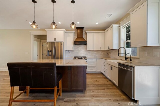 13654 Andover Dr, Magalia, CA 95954 - kitchen featuring custom exhaust hood, stainless steel appliances, a kitchen island, light wood-style floors, and tasteful backsplash