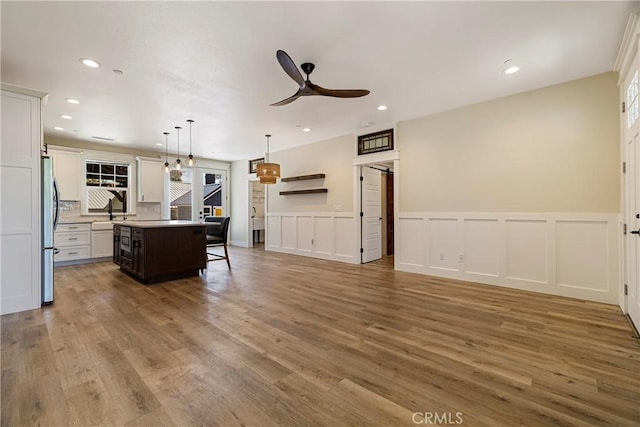 13654 Andover Dr, Magalia, CA 95954 - kitchen featuring ceiling fan, open floor plan, wood finished floors, a kitchen breakfast bar, and freestanding refrigerator