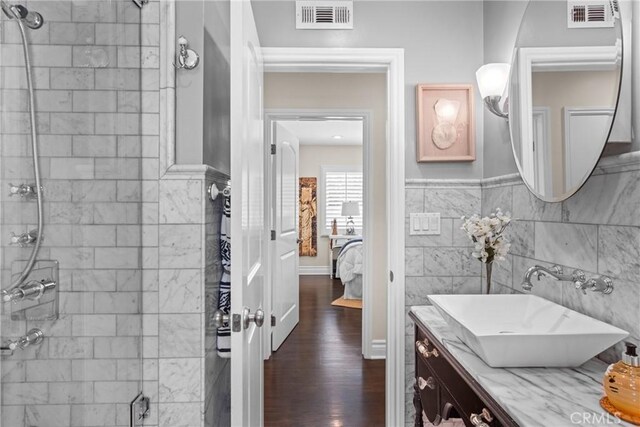 17652 Fiesta Way, Tustin, CA 92780 - ensuite bathroom with tiled shower, vanity, wood finished floors, and tile walls