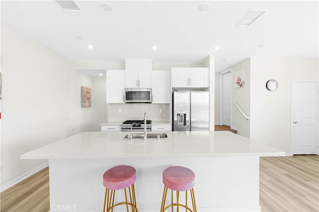1570 Topia Ave, Placentia, Placentia, CA 92870 - kitchen with stainless steel appliances, a sink, light wood-type flooring, a kitchen island with sink, and light countertops