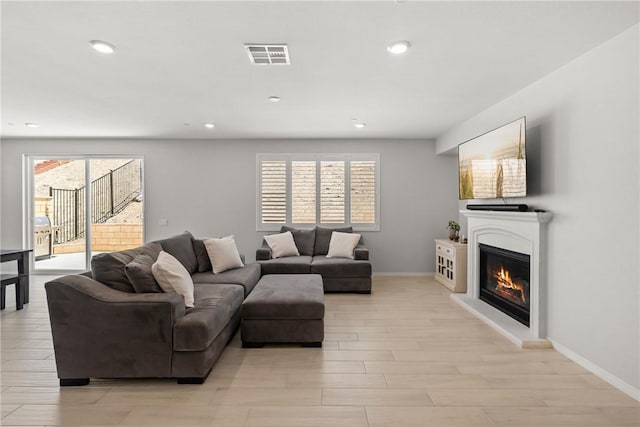 33168 Toledo Bend Ct, Winchester, CA 92596 - living room with a glass covered fireplace, light wood-style flooring, and recessed lighting