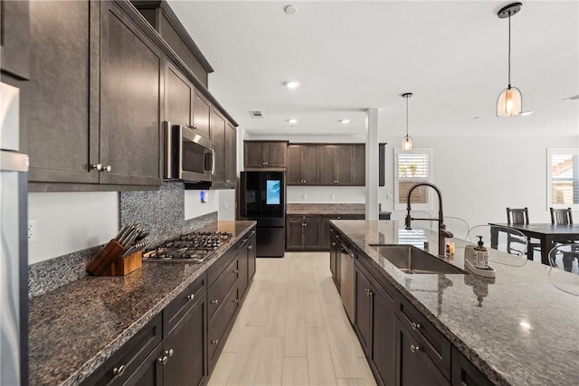 33168 Toledo Bend Ct, Winchester, CA 92596 - kitchen with stainless steel appliances, plenty of natural light, dark stone counters, dark brown cabinetry, and recessed lighting