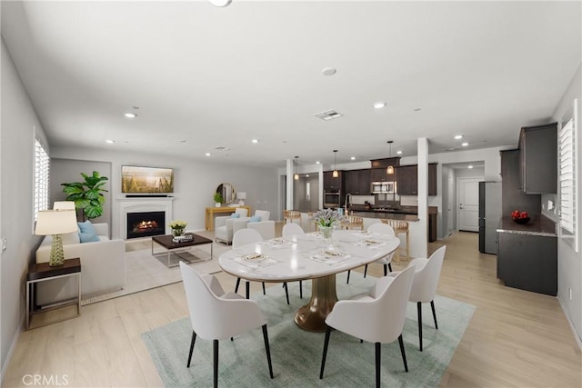 33168 Toledo Bend Ct, Winchester, CA 92596 - dining space with a lit fireplace, recessed lighting, and light wood-type flooring
