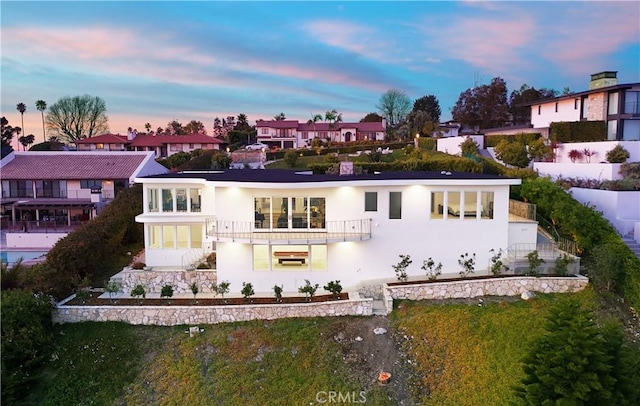 43 Oceanaire Dr, Rancho Palos Verdes, CA 90275 - back of property at dusk with a balcony, stucco siding, and a residential view