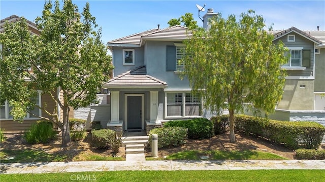 39 Windward Way, Buena Park, CA 90621 - obstructed view of property featuring a tiled roof, stucco siding, and a chimney