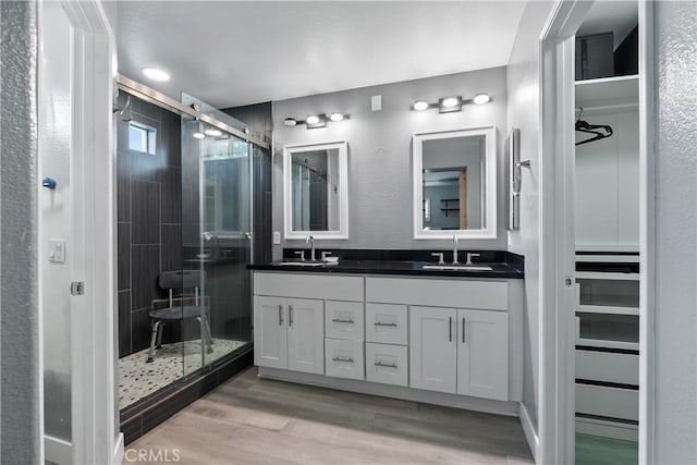 39 Windward Way, Buena Park, CA 90621 - full bathroom with double vanity, a stall shower, wood finished floors, a textured wall, and a spacious closet