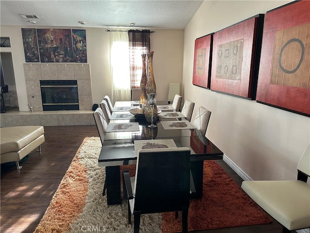 20159 Majestic Dr, Apple Valley, CA 92308 - dining space featuring wood finished floors, a textured ceiling, and a tiled fireplace
