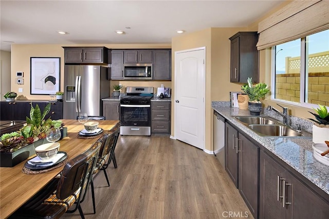 8504 Peachwillow Ct, Jurupa Valley, CA 92509 - kitchen featuring appliances with stainless steel finishes, a sink, dark wood-style floors, dark brown cabinets, and light stone counters