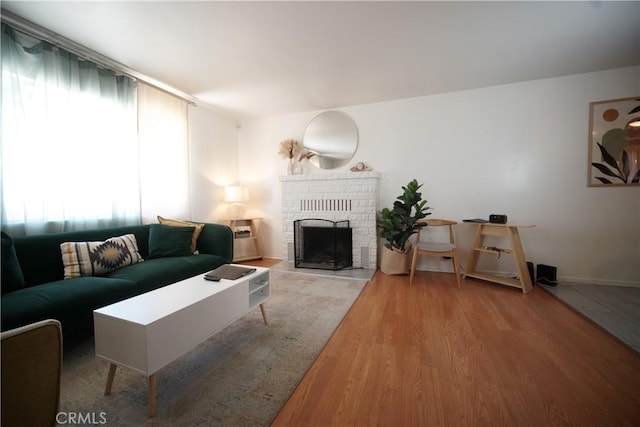 61740 Oleander Dr, Joshua Tree, CA 92252 - living area featuring plenty of natural light, wood finished floors, and a brick fireplace