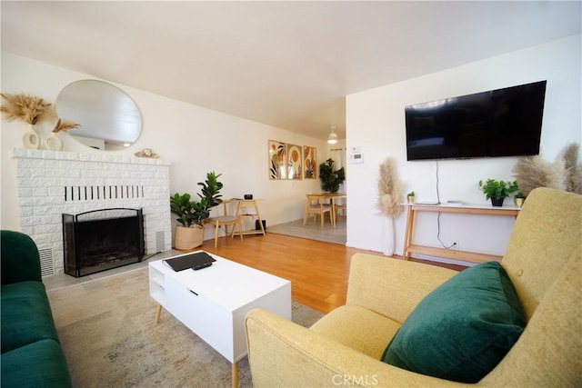 61740 Oleander Dr, Joshua Tree, CA 92252 - living area with a brick fireplace and wood finished floors