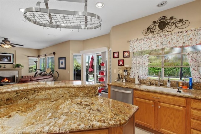 33370 Morning View Dr, Temecula, CA 92592 - kitchen with dishwasher, ceiling fan, light stone counters, a tiled fireplace, and open floor plan