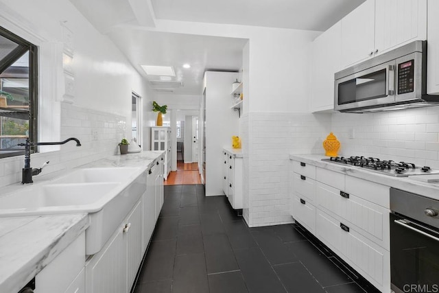 3818 Herbert St, San Diego, CA 92103 - kitchen with appliances with stainless steel finishes, white cabinets, a sink, and dark tile patterned floors
