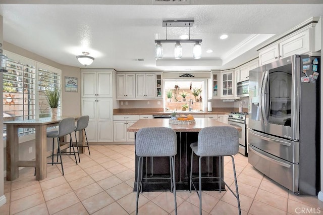 15414 Ficus St, Chino Hills, CA 91709 - kitchen with stainless steel appliances, light tile patterned floors, a sink, and a breakfast bar