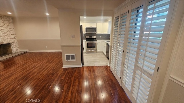 22947 Nadine Cir Unit A, Torrance, CA 90505 - kitchen featuring stainless steel appliances, white cabinets, wood finished floors, crown molding, and decorative backsplash