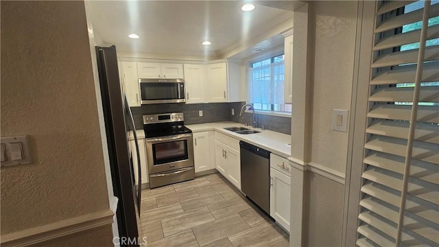 22947 Nadine Cir Unit A, Torrance, CA 90505 - kitchen featuring stainless steel appliances, decorative backsplash, white cabinets, a textured wall, and light countertops