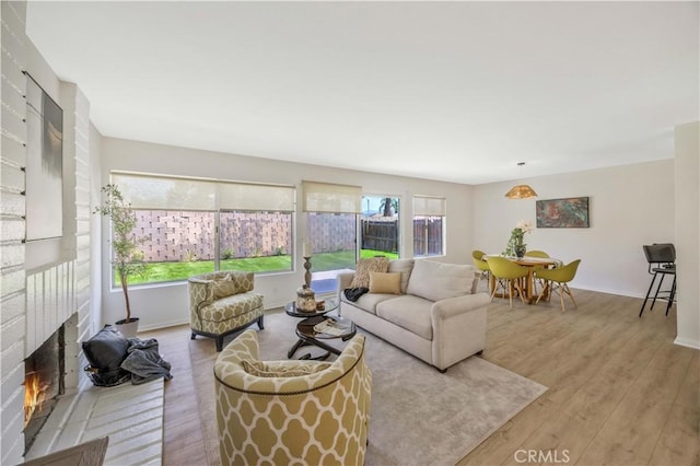 23326 Elfin Pl, Moreno Valley, CA 92557 - living room featuring wood finished floors and a brick fireplace