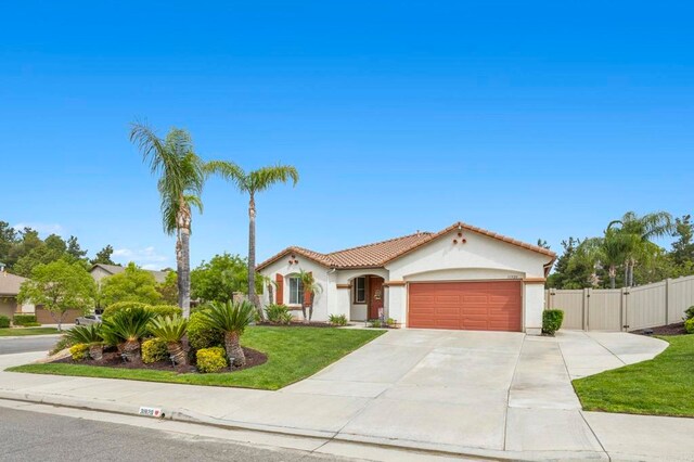 31920 Pasos Pl, Temecula, CA 92591 - mediterranean / spanish house with a gate, an attached garage, stucco siding, concrete driveway, and a tiled roof