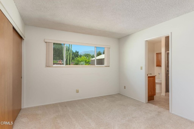 4190 Ojai Rd, Santa Paula, CA 93060 - unfurnished bedroom with light colored carpet, a closet, a textured ceiling, and ensuite bath
