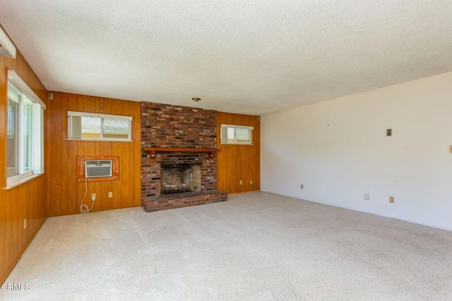 4190 Ojai Rd, Santa Paula, CA 93060 - unfurnished living room with a textured ceiling, an AC wall unit, carpet, wood walls, and a fireplace