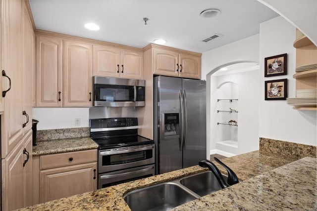 3890 Nobel Dr Unit 1505, San Diego, CA 92122 - kitchen featuring appliances with stainless steel finishes, light brown cabinetry, arched walkways, light stone counters, and open shelves
