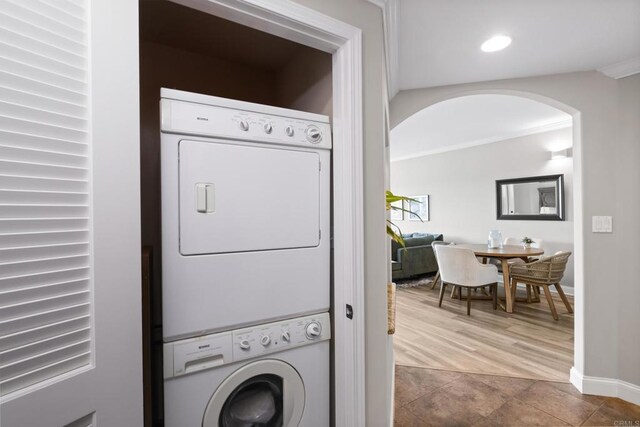 3890 Nobel Dr Unit 1505, San Diego, CA 92122 - laundry room featuring stacked washing machine and dryer, crown molding, arched walkways, recessed lighting, and tile patterned flooring