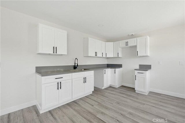44242 Benald St, Lancaster, CA 93535 - kitchen featuring a sink, light wood-style floors, baseboards, and white cabinets