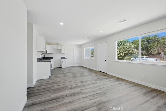 44242 Benald St, Lancaster, CA 93535 - unfurnished living room with baseboards, a sink, light wood-style floors, and recessed lighting