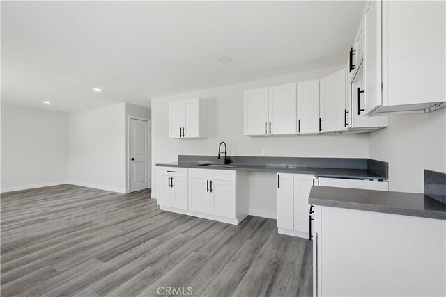 44242 Benald St, Lancaster, CA 93535 - kitchen with a sink, light wood-style floors, recessed lighting, dark countertops, and baseboards